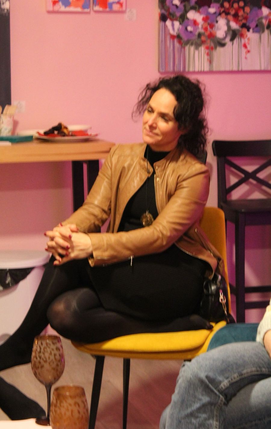 Sandy assise, souriante, qui écoute pendant une rencontre.
